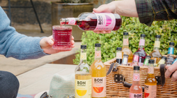 lots of Bon Accord in a picnic basket. Bon Accord Rhubarb Soda is being poured into a glass