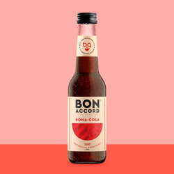 Bottle of Bon Accord Bona-Cola against pink and red backdrop